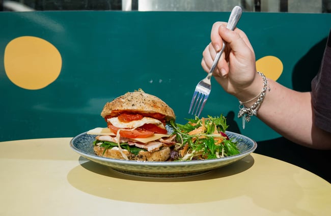 A burger and salad on a plate.