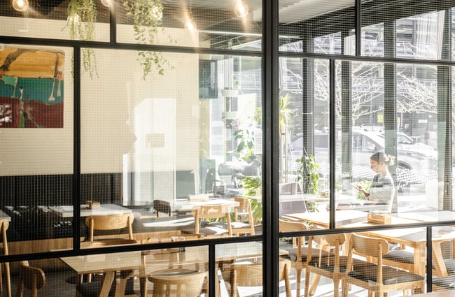 Pale wood wall and cafe seating with industrial lights at Westend Stories..