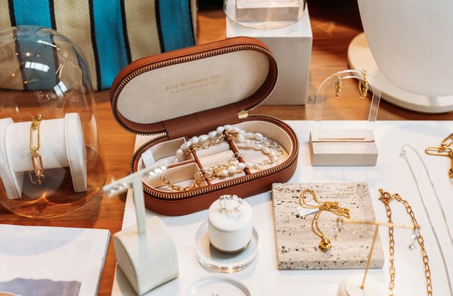 Close up of pearl jewellery inside brown leather jewellery case with the inscription "Keep the country close"