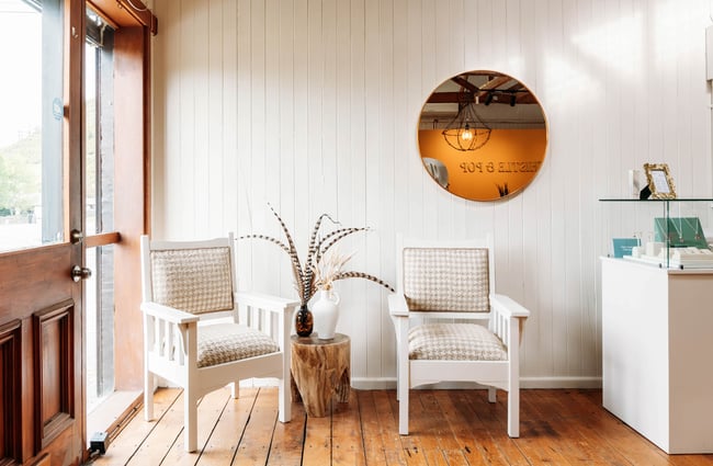 Two white and tweed chairs by the doorway of Whistle & Pop