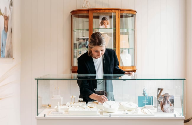 Woman reaching into jewellery cabinet at Whistle & Pop