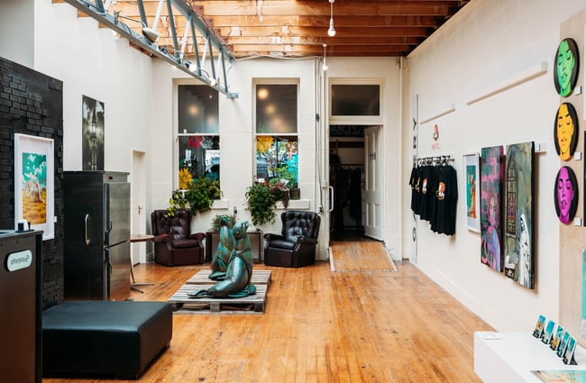 Overview of Wicksey's industrial studio and gallery space with leather armchairs, seal sculptures and paintings on the walls
