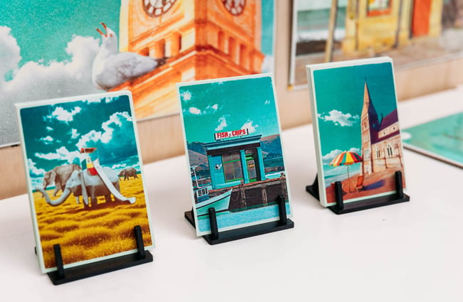 Close up of small art prints featuring a nostalgic elephant slide and fish and chip shop