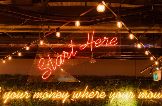 A fluorescent sign that says 'start here'.