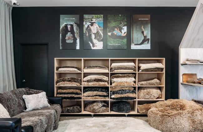 Big wooden cubbyholes housing 'The Sheepskin Bar' of various sheepskin rugs at Wilson & Dorset in Wānaka.