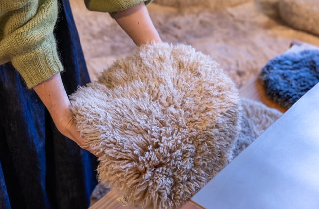 A customer picks up a sheepskin rug in Wilson & Dorset.