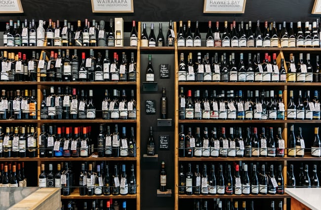 Wall of wine bottles on shelves at Wine Craft.