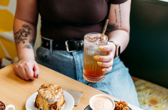 Customer holding a drink at Wooden Spoon.