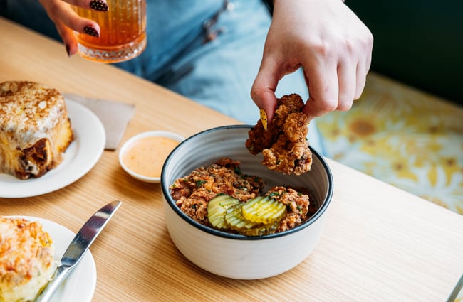 Customer eating fried chicken at Wooden Spoon.