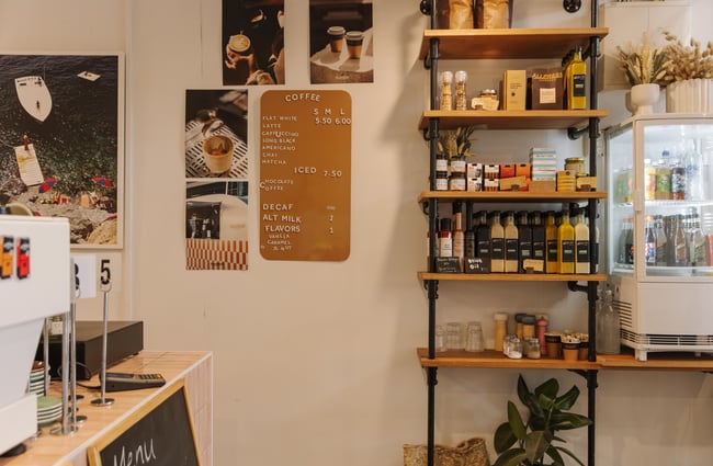 Menu on the wall and shelf with products on it at Woods Cafe.