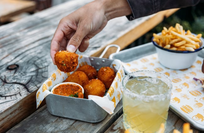 Hands holding a deep fried ball.