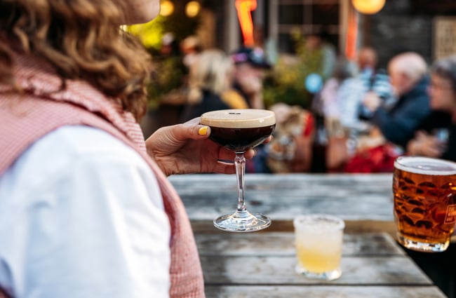 A hand holding an espresso martini.