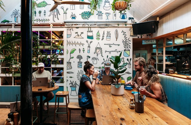 Customers dining at a long cafe counter.