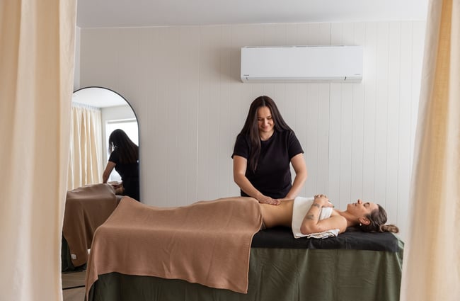 Customer is lying on massage table and massage therapist is behind at yourSPAce.