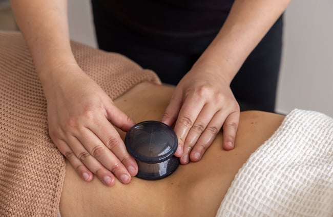Massage therapist uses tool on a customer at yourSPAce.