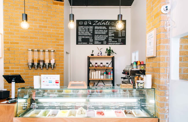 Plywood and white shop interior with ice cream freezer.
