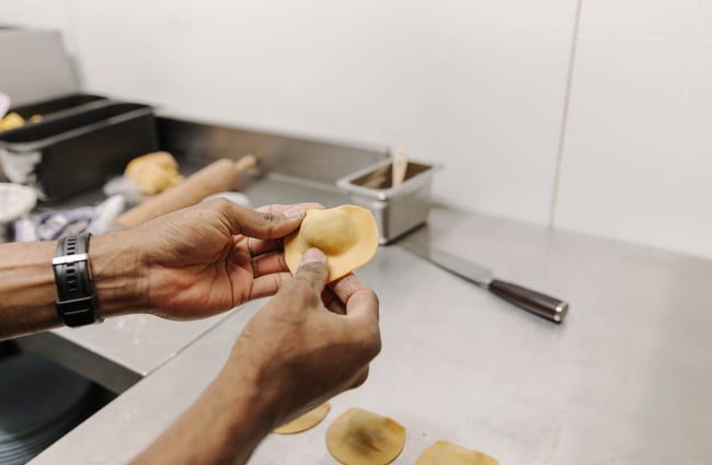 Chef hand finishing the ravoli in the kitchen at Zephyr.