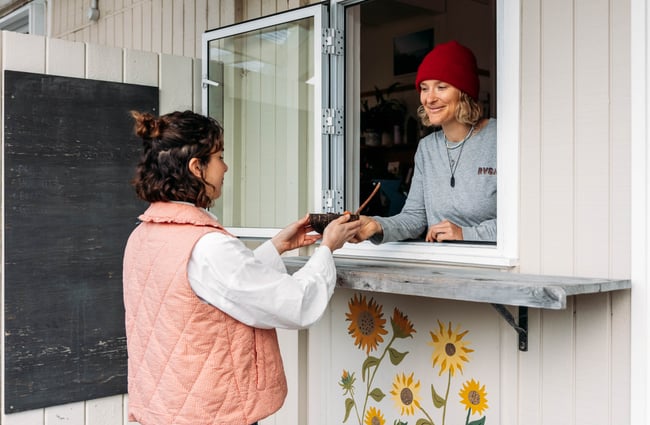 A customer being served through a small serving window.