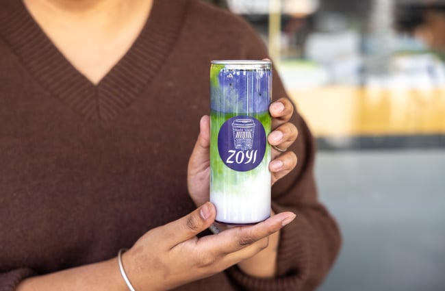 Server holding matcha in a can at Zoyi.