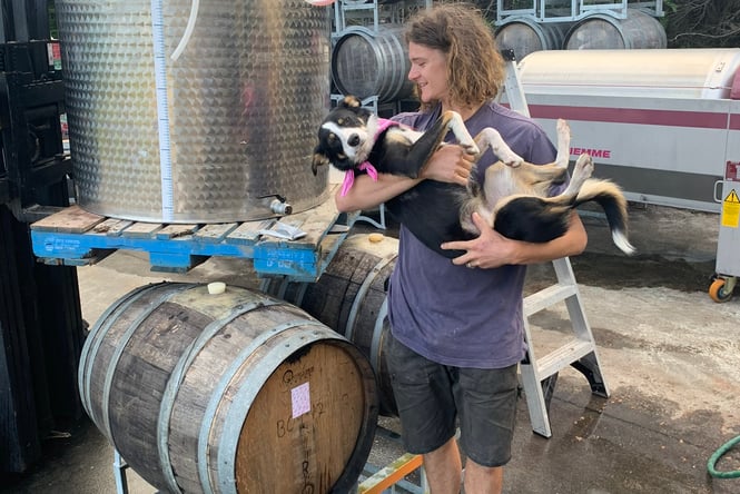 A man making holding a dog like a baby.