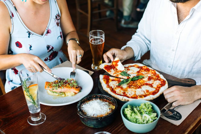 Diners eating Italian food at a table.