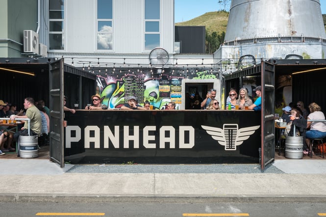 People dining behind a painted mural.