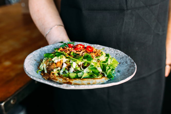 Close up of a waiter holding Federal Diner's pulled pork roti dish.