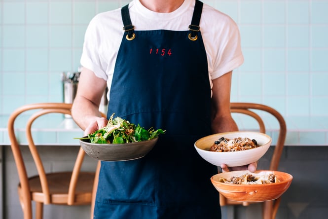 Waiter holds three dishes at 1154, Wellington.