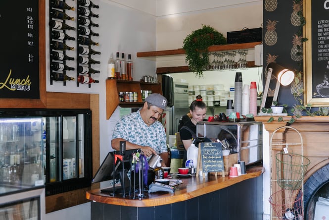 Two people behind the counter at Beach House Cafe.