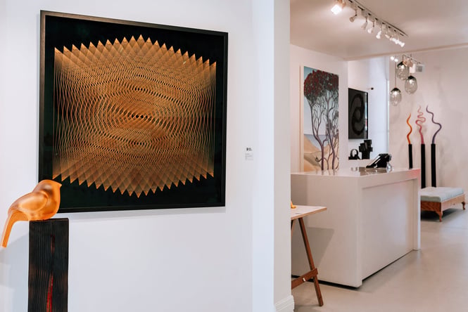 Various artworks on display including a glass bird in the foreground at Black Door Gallery, Auckland.