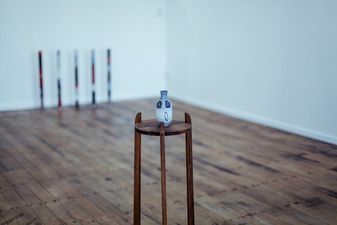 Urn on a stand on the wooden floor.