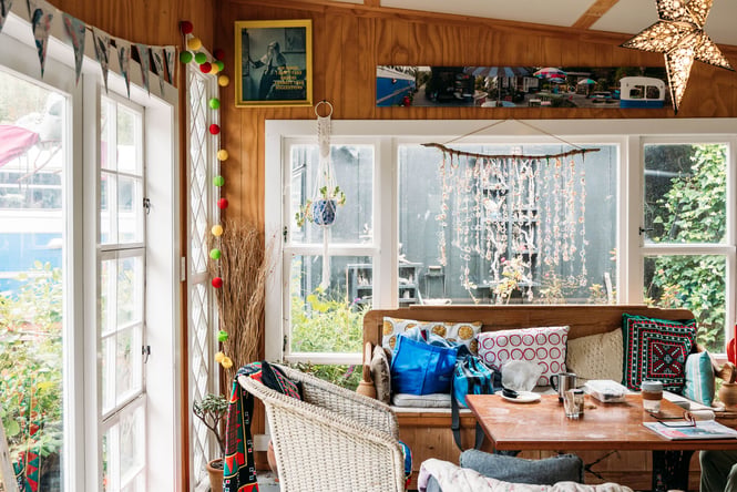 A vintage living room sitting next to large windows.