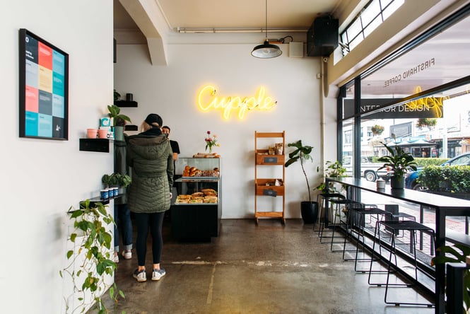 A woman standing at the counter inside Cupple cafe Hastings.