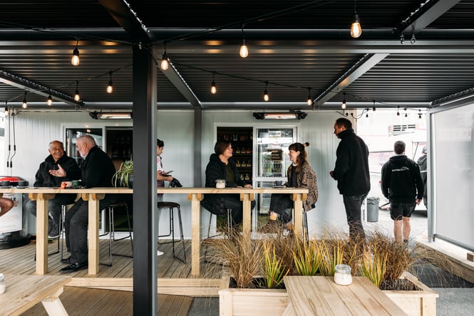Customers chatting at tables outside the cafe.