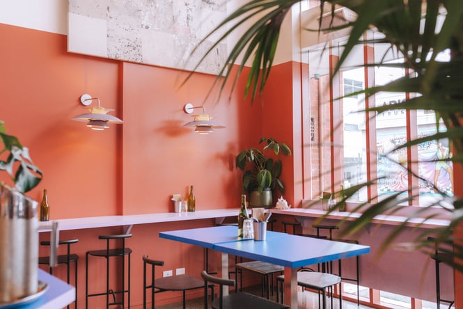 A blue high table with bench seats inside the restaurant.