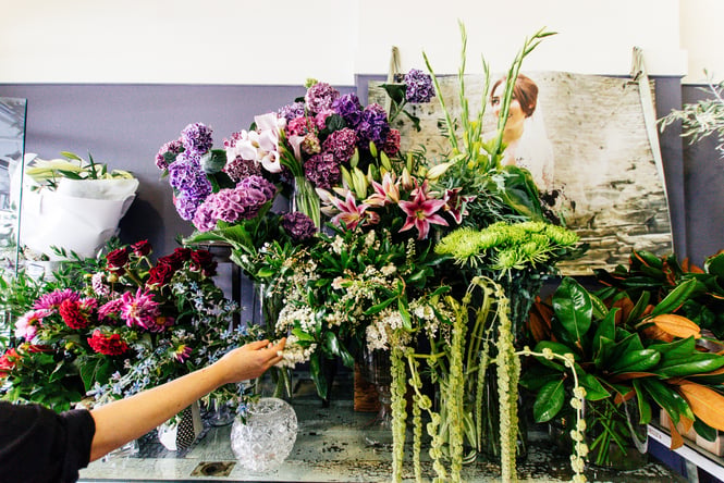 A hand reaching for flowers.