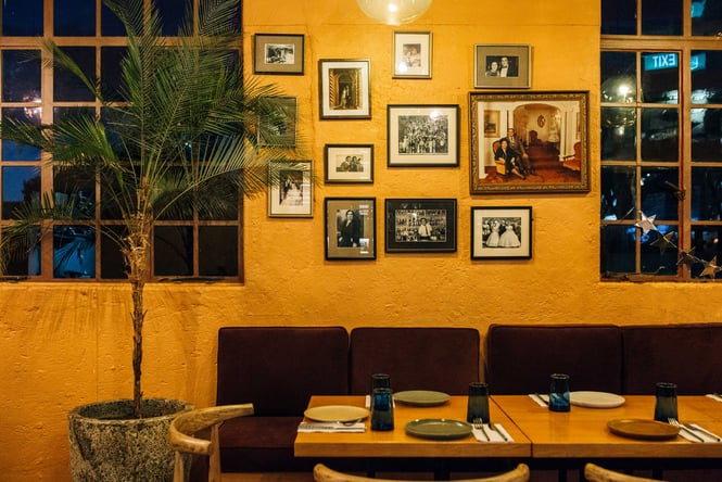 Close up of seating area and old photographs and artwork on the wall at Gemmayze Street.