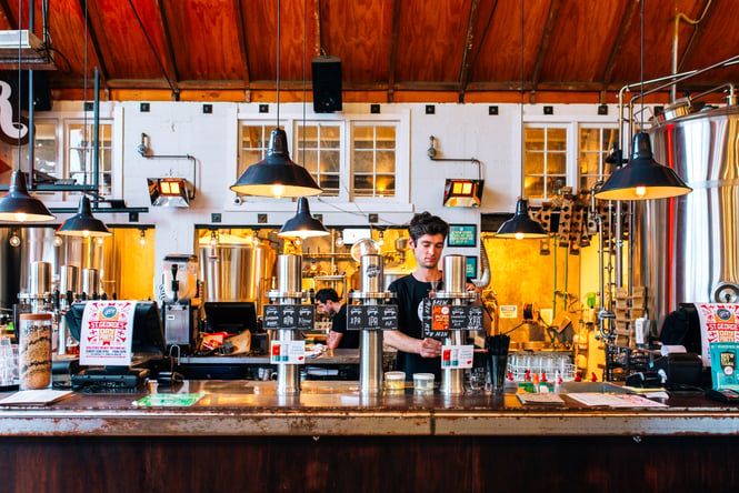 Bartender behind the bar at Good George Dining Hall, Hamilton.