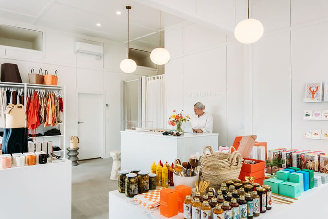 A woman working behind a white counter in a beautifully decorate store.