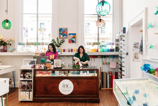 Two women standing behind the counter at Inc. Design Store in Ōamaru