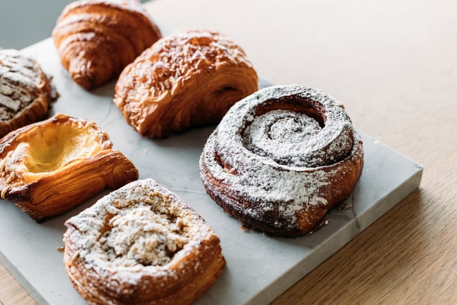 Pastries on a board on top of a wooden counter.