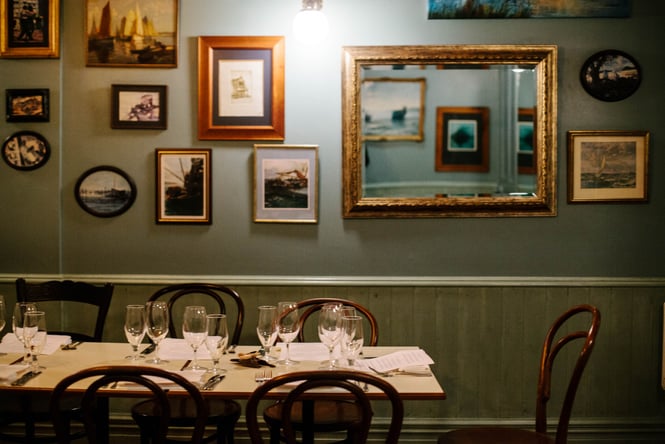 Table by photo frames on wall.