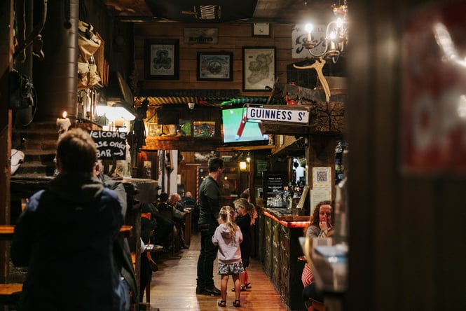 Man standing at the bar with his children at Strawberry Tree.