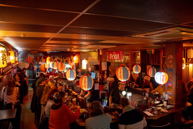 A packed restaurant on a dark night.