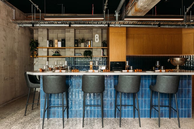 High seats placed around a kitchen and bar area.