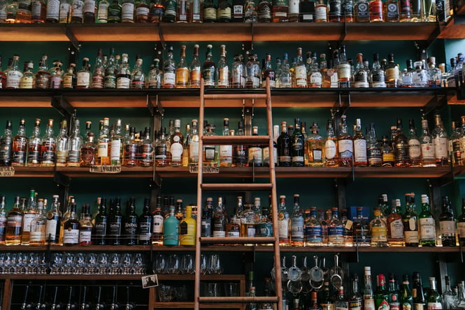 Close up of liquor bottles on a shelf.
