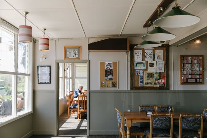 Seating area with noticeboard on the wall at The Moutere Inn, Nelson Tasman.