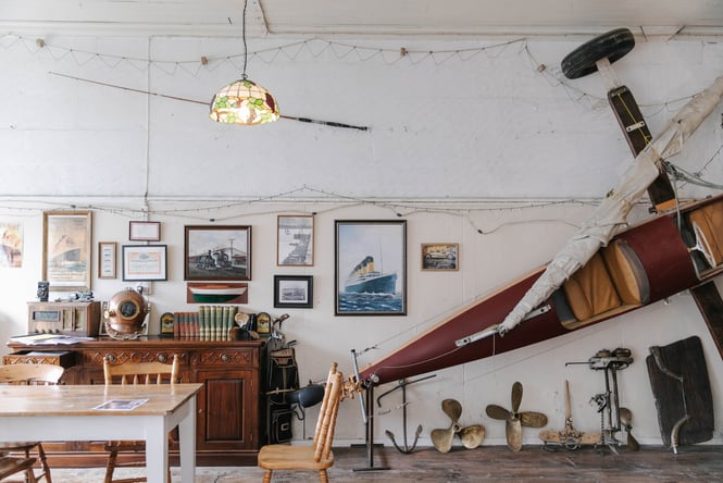 Old artifacts on a dresser and land yacht at The Terraces with table in foreground in Ōamaru.