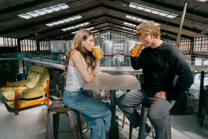 Two people drinking at table on mezzanine area of Three Boys Brewery in Christchurch.