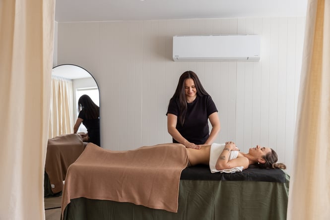 Customer is lying on massage table and massage therapist is behind at yourSPAce.
